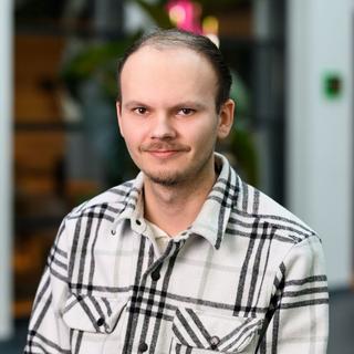 a man in a plaid shirt posing for a picture